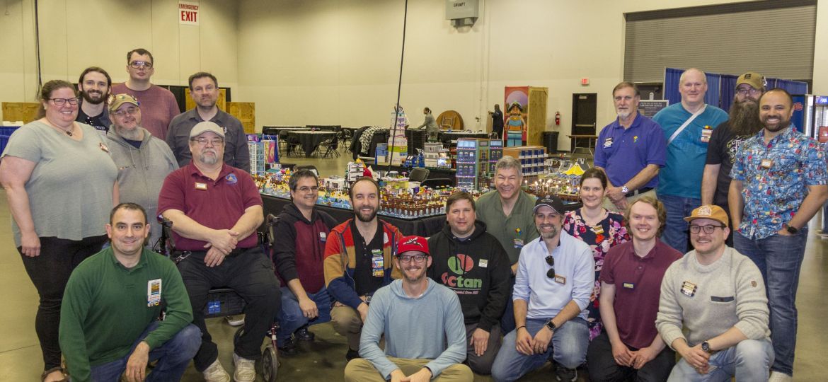 A group gathered in a large expo center for a group photo.