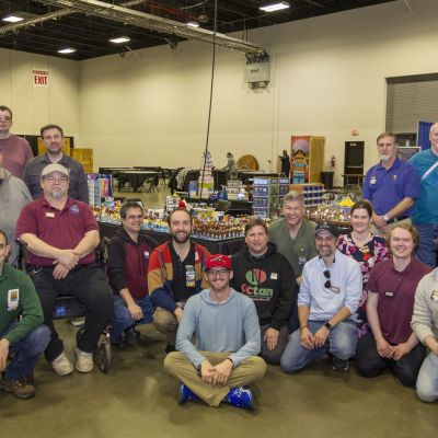 A group gathered in a large expo center for a group photo.